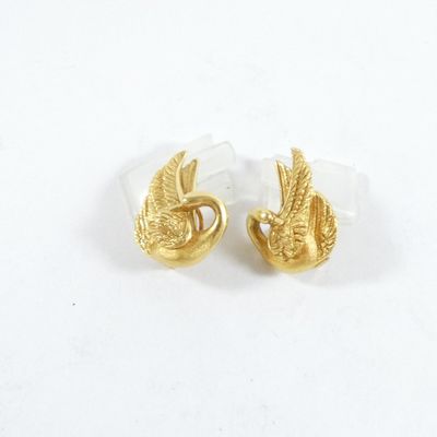 une paire de boucles d'oreilles clous en forme d'oiseaux, de couleur dorée, sur fond blanc