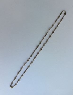 un collier en argent dont l'extrémité est ornée d'une chaîne