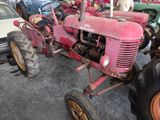 a pink tractor that is parked in a garage