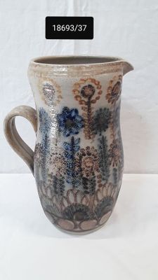 a picture of a ceramic pitcher with a floral design on it