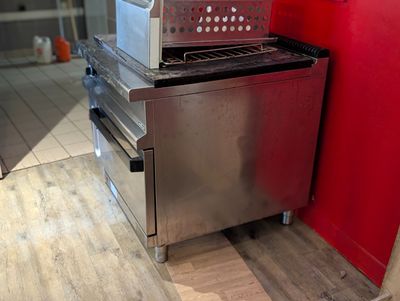 un micro-ondes posé sur une cuisinière dans une cuisine