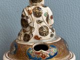 a close up of a vase with a person sitting on top of it