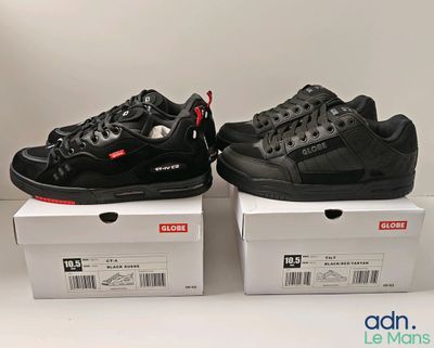 Deux paires de baskets noires et rouges sont posées sur des cartons.