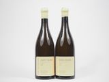 deux bouteilles de vin posées l'une à côté de l'autre sur une surface blanche
