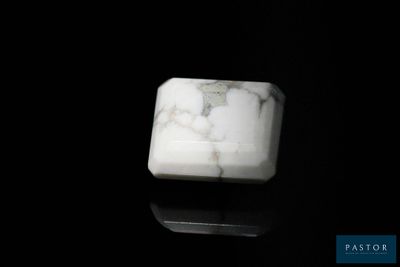 une photo d'un bloc de marbre blanc posé sur une surface noire