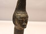 bronze head of a woman with a cone on her head