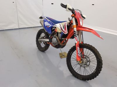une moto tout-terrain rouge et bleue garée dans une pièce
