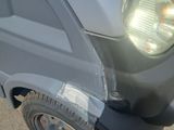 a car that has been dented and is parked on the side of the road