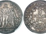 a silver coin with a picture of a woman and a man on it
