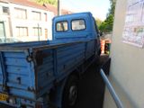 a blue truck that is parked on the side of the road