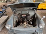 an old car that is sitting in the garage with its hood open