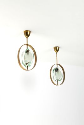 une paire de boucles d'oreilles en verre vert et en laiton suspendues au plafond