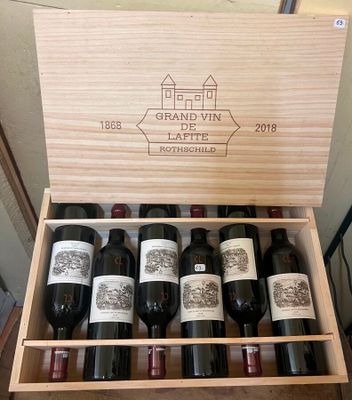 bottles of wine are in a wooden box on a table