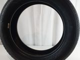 a close up of a tire on a white surface with a curtain in the background