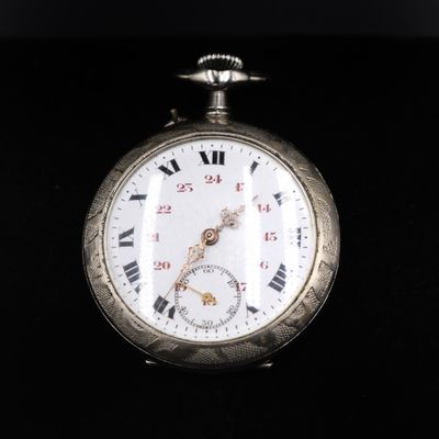 a silver pocket watch with roman numerals on it