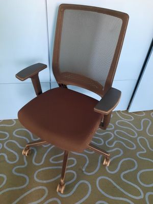 an image of a brown office chair sitting on top of a carpet