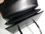 a person holding a black purse with two zippers