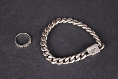 un bracelet en argent et une bague sur un fond noir