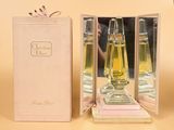 un flacon de parfum posé dans une boîte à côté d'une boîte de parfums