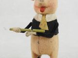 a figurine of a pig wearing a tie and holding a stick