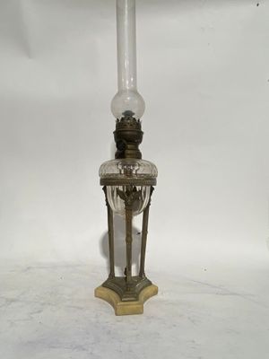 an old fashioned lamp with a glass shade on top of it