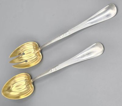 a set of three silver and gold serving spoons