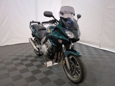 une moto qui est garée dans une pièce dont le sol est en damier