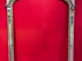 an ornately carved fireplace surround with a red wall in the background
