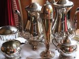 a silver tea set on a silver tray on a table