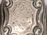 an antique silver box with a decorative design on the front