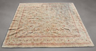 un vieux tapis avec une bordure rouge sur fond gris