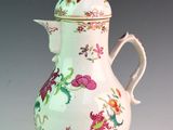 a white vase with a pink flower design on it