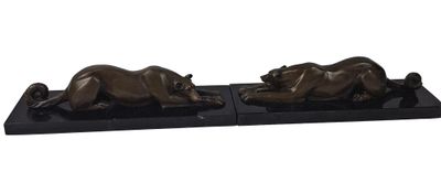 a pair of bronze sculptures of two lions on a black base