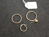 three pairs of gold hoop earrings and a gold ball earring