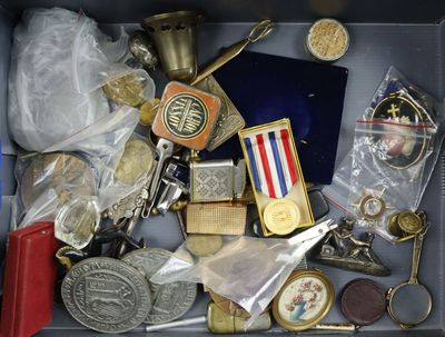 une boîte remplie d'objets divers, parmi lesquels des médailles et d'autres objets