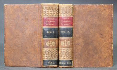 two old books sitting on top of each other on a table