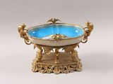gold and blue glass bowl on stand on white background