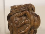 a small glass jar with a wooden face on it next to a small glass jar with a wooden face on it