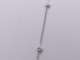 a close up of a silver necklace with a diamond on a chain