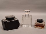 three different bottles of perfume on a white surface