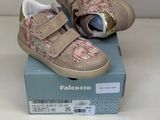 une paire de chaussures pour tout-petits dans une boîte posée sur une surface blanche