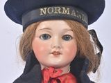 a doll that is wearing a hat and a tie
