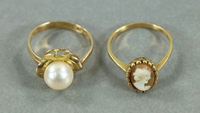 deux bagues en or ornées de perles et d'un coquillage au centre