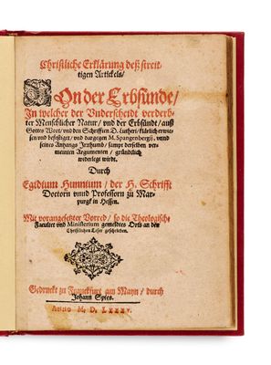 un vieux livre à la couverture rouge posé sur une table
