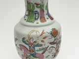 a white vase with a painting on it sitting on a table