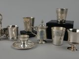 several silver cups and saucers are sitting on a table
