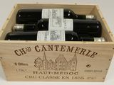 bottles of wine are in a wooden box on a white surface