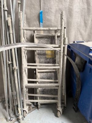 une pile de chaises et une poubelle bleue dans une pièce