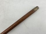 a wooden stick with a metal handle on a white surface