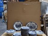 many plates and bowls sitting on a table in a warehouse